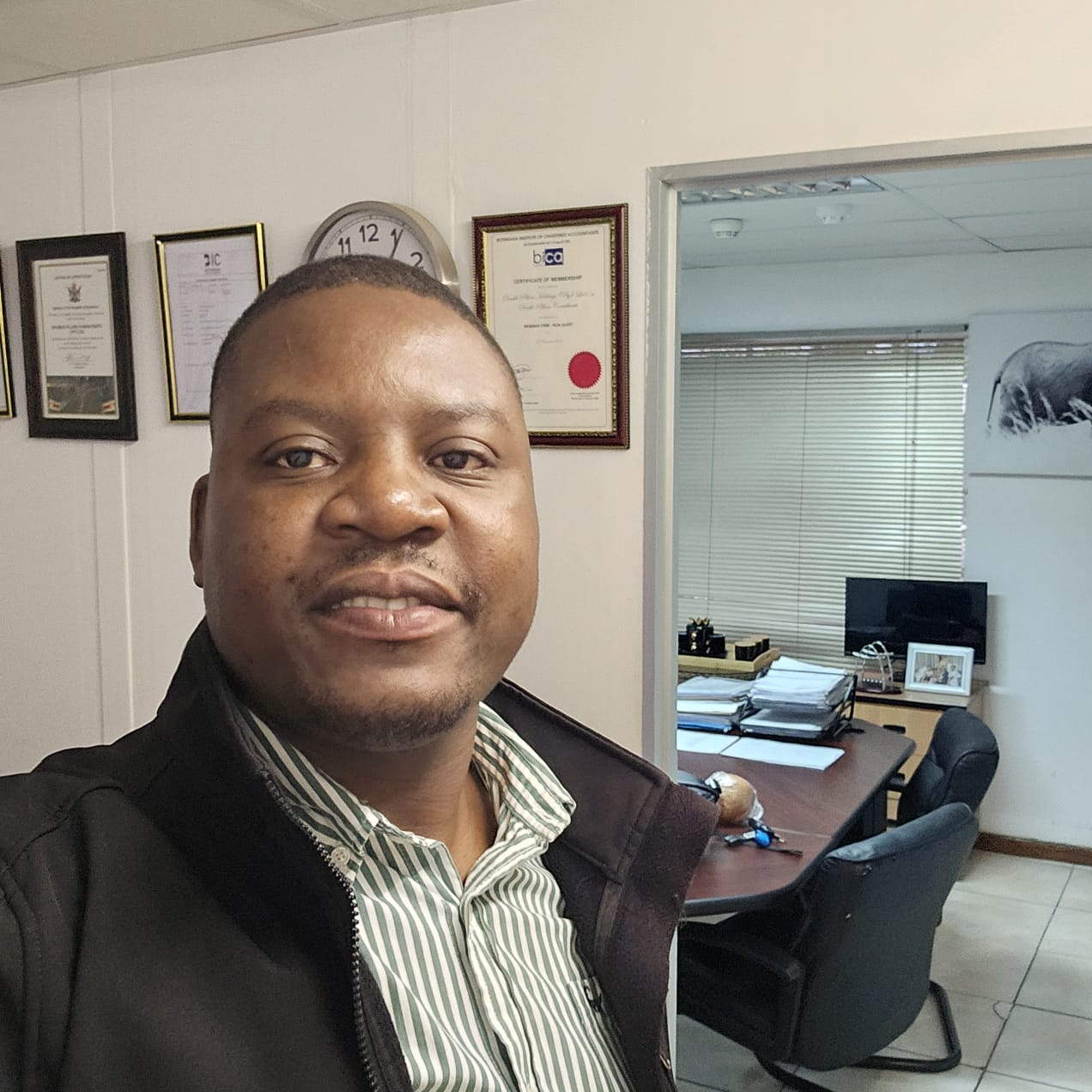 Double Pillars consultant in an office with framed professional certificates.